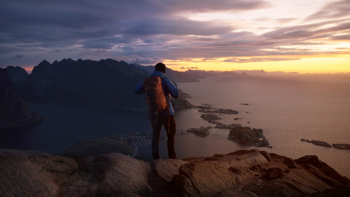 Graded frame: hiker above a coastal sunset